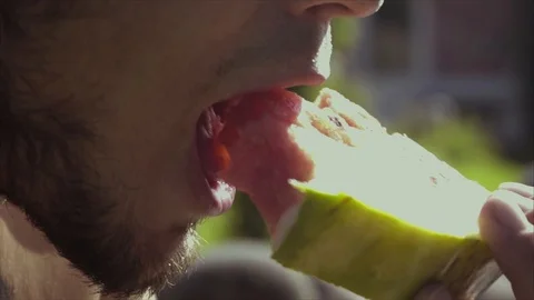 A young man eats a watermelon. Close-up. Slow motion 動画素材 95560570