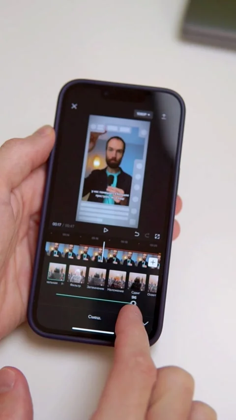 A young man is editing a video on his smartphone Stock Footage 238083900