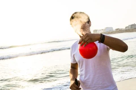 Young man with electronic cigar and a red balloon Stock Photos