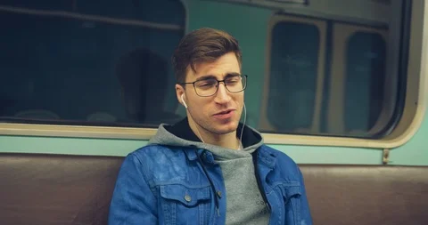 Young man emotionally and gesticulating sings a song in the car. Guy in glasses Vídeo Stock 108563241