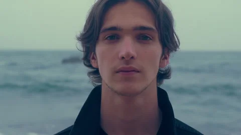 Young man  on the empty ocean beach, on the cloudy rainy weather. Confident.. Stock Footage 261804715