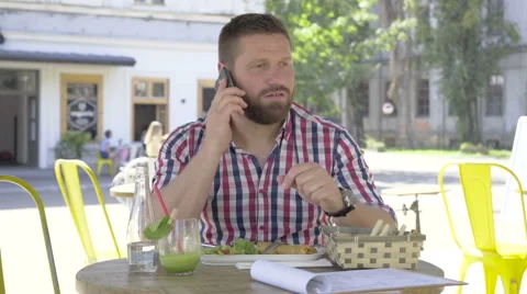 Young man ends call and looks at camera, during lunch. 库存影片 67604266