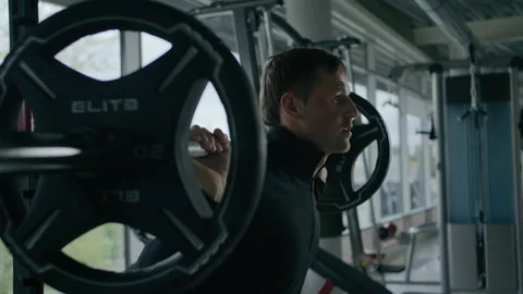 Young man is engaged in crossfit, doing leg exercises, warming up, in the gym. Stock Footage 130413536