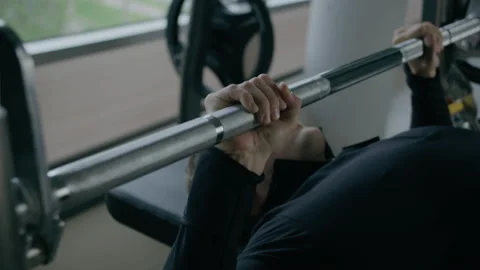 Young man is engaged in crossfit, doing chest exercise, warming up, in the gym. Stock Footage 130415471