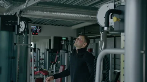Young man is engaged in crossfit, doing pull-up, warming up, in the gym. Stock Footage 130417725