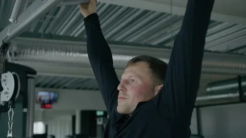 Young man is engaged in crossfit, doing pull-up, warming up, in the gym. Stock Footage 130418009