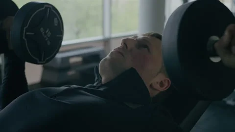 Young man is engaged in crossfit, doing chest exercise, warming up, in the gym. Stock Footage 130419457