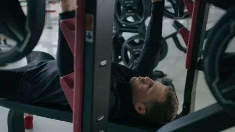 Young man is engaged in crossfit, doing chest exercise, warming up, in the gym. Stock Footage 130420548