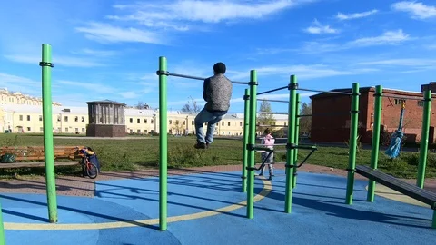 A young man is engaged on a horizontal bar Stock Footage 130116546