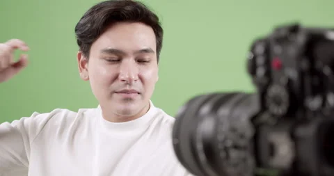 A young man engages in a video tutorial in a home studio showcasing the Vídeos de archivo 297370270