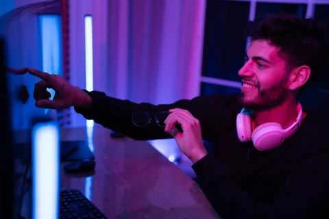 Young man engaging with computer screen in a modern gaming setup at home du.. Foto stock