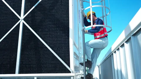 Young man engineer climbing a metal ladder to inspect industrial equipment Видео 339645168