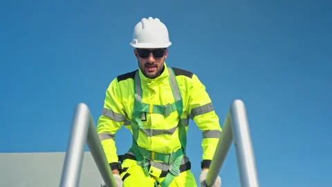 Young man engineer climbing a metal ladder to inspect industrial equipment 스톡 동영상 339646846