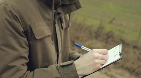 Young man engineer on the field with pen and paper Stock Footage 63849583