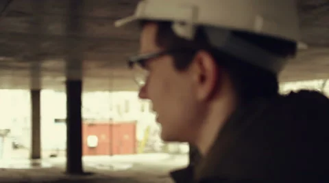 Young man engineer in helmet on the building project Stock Footage 63794534
