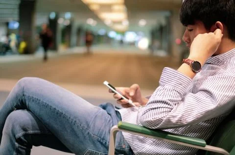 Young man enjoy using smart phone while waiting for airplan Foto stock