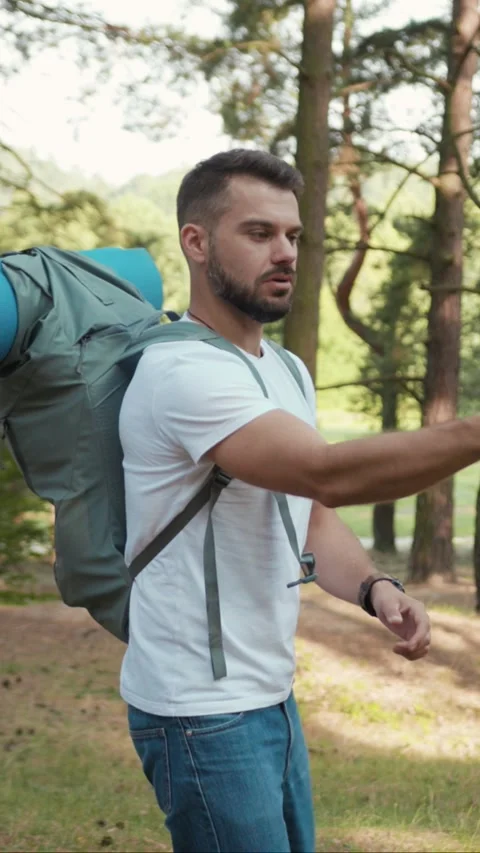 A Young Man Enjoyfully Hiking in the Forest while Carrying His Camping Gear with Stock Footage 314167895