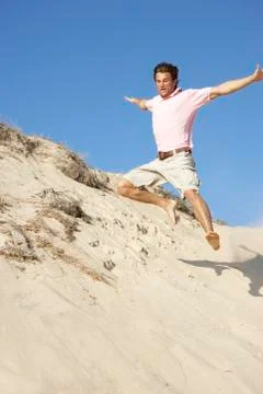Young Man Enjoying Beach Holiday Running Down Dune Stock Photos