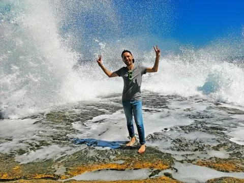 Young man enjoying high waves with water waves with splashes Stock Photos
