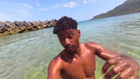 Young man enjoying summer vacation, swimming and splashing in ocean Stock Footage 310523445