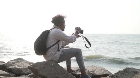 Young man enjoying time by the beach with his camera portrait Stock Footage 108330384