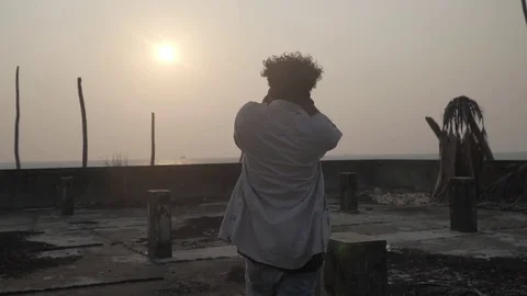 Young man enjoying time taking photos silhouette moody youth sunset vintage Stock Footage 107809411