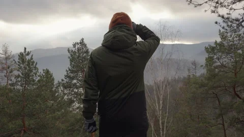 Young man enjoys the beautiful view of mountain valley on the mountain top Stock Footage 232302400