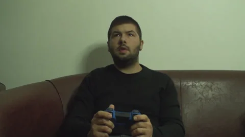 Young Man Enjoys Playing A Console Game On His Sofa Front Shot Vídeo Stock 33672138