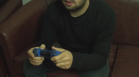 Young Man Enjoys Playing A Console Game On His Sofa Closeup Shot Stock-Footage 33674545
