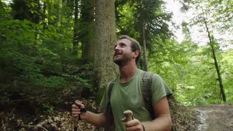Young man enjoys the view of the blue sky from mountain road. Look up. Solo trip Stock Footage 208888122