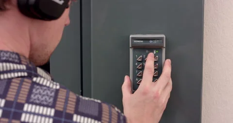A young man entering an access code on a home security keypad Stock Footage 238761297