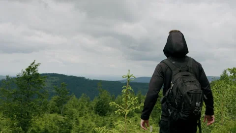 Young man entering frame, standing on the top of a mountain 4K. Stock Footage 234555308