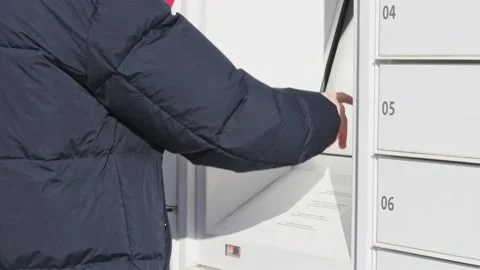 A young man enters a code on a mailbox. Stock Footage 234230483
