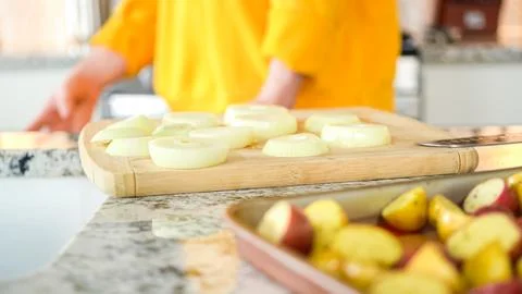 Young Man Enthusiastically Preparing Dinner in Modern Kitchen Stock Photos