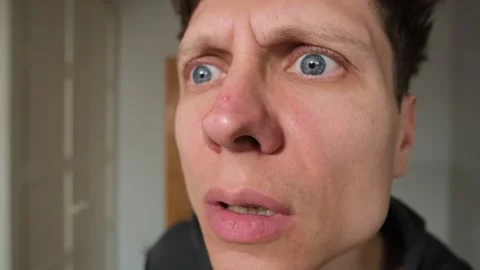 A young man examines a red pimple on his nose with dissatisfaction, his wide Stock Footage 306658074