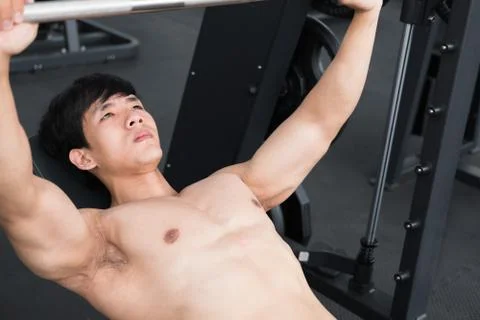 Young man execute exercise with weightlifting machine in fitness center. male Stock Photos
