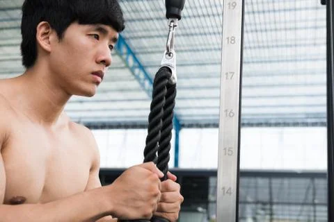 Young man execute exercise with weightlifting machine in fitness center. male Stock Photos