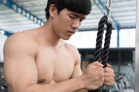 Young man execute exercise with weightlifting machine in fitness center. male Stock Photos