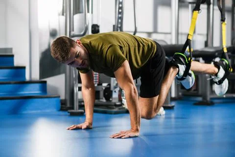 Young man exercise trx workout in gym Stock Photos