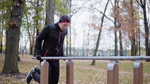 A young man exercises on a pole in a park. Vídeo Stock 124729389