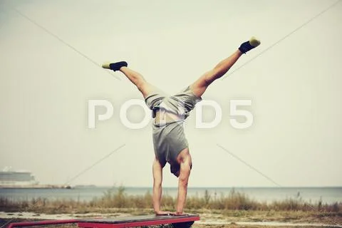 Young man exercising on bench outdoors Stock Photos