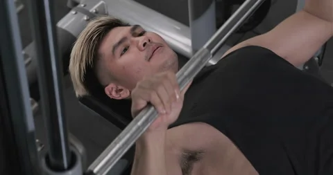 Young man exercising bench press chest on the bench with barbell Stock Footage 137034699
