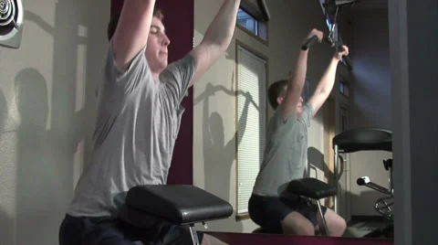Young man exercising his upper body. Using a machine. Stock Footage 49863018