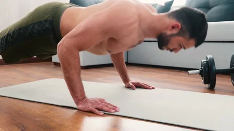 Young man exercising at home. Guy stand on hands and doing push-up ecercise Stock Footage 131512455
