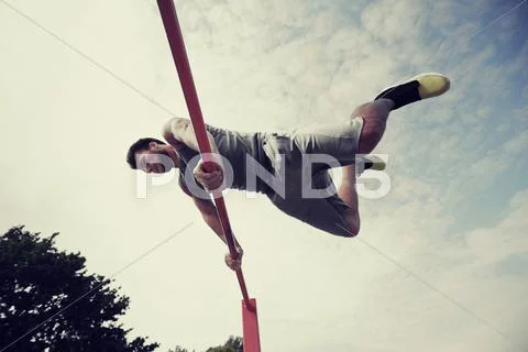 Young man exercising on horizontal bar outdoors Stock Photos