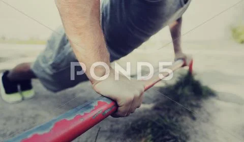 Young man exercising on horizontal bar outdoors Stock Photos