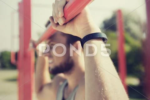 Young man exercising on horizontal bar outdoors Stock Photos