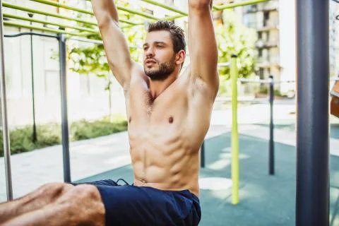 Young man exercising outside. Close up and cut view of strong powerful well Stock Photos