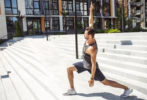 Young man exercising outside. Guy standing in semi squat position or yoga pose Stock Photos