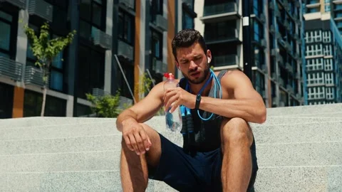 Young man exercising outside. Slow motion of serious athlete using jumping rope Stock Footage 136406926